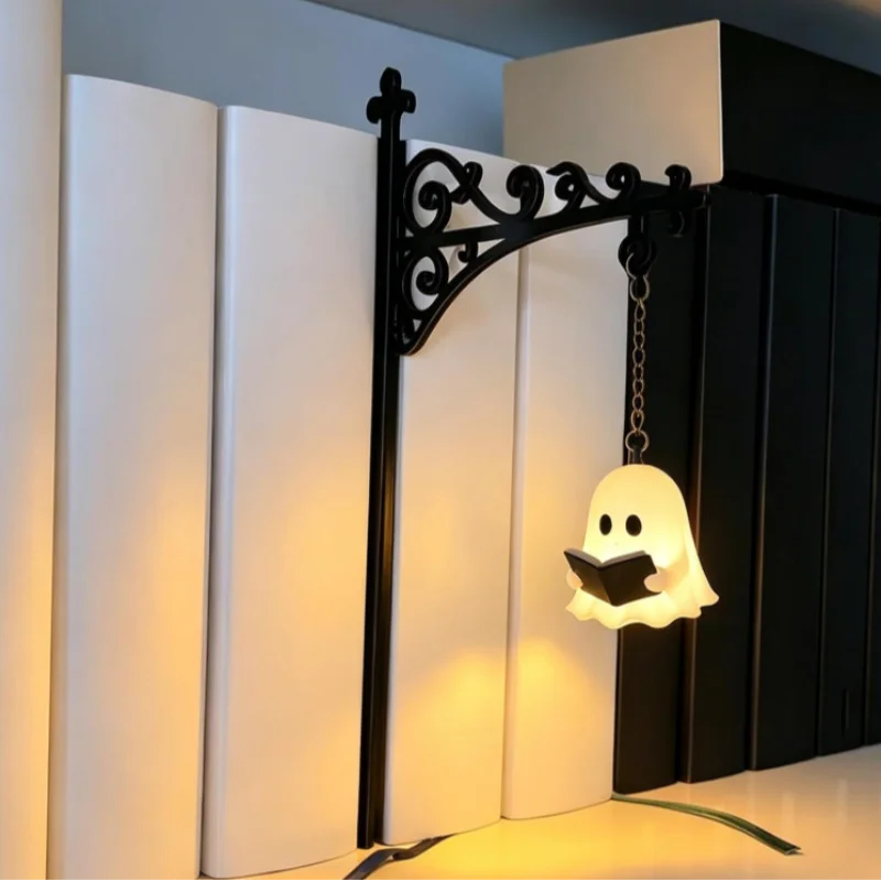 The Ghost variant hooked onto a white shelf, its small reading figure glowing warm amber