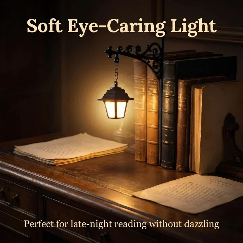 The lantern lighting an open book on a wooden desk beside a stack of antique volumes